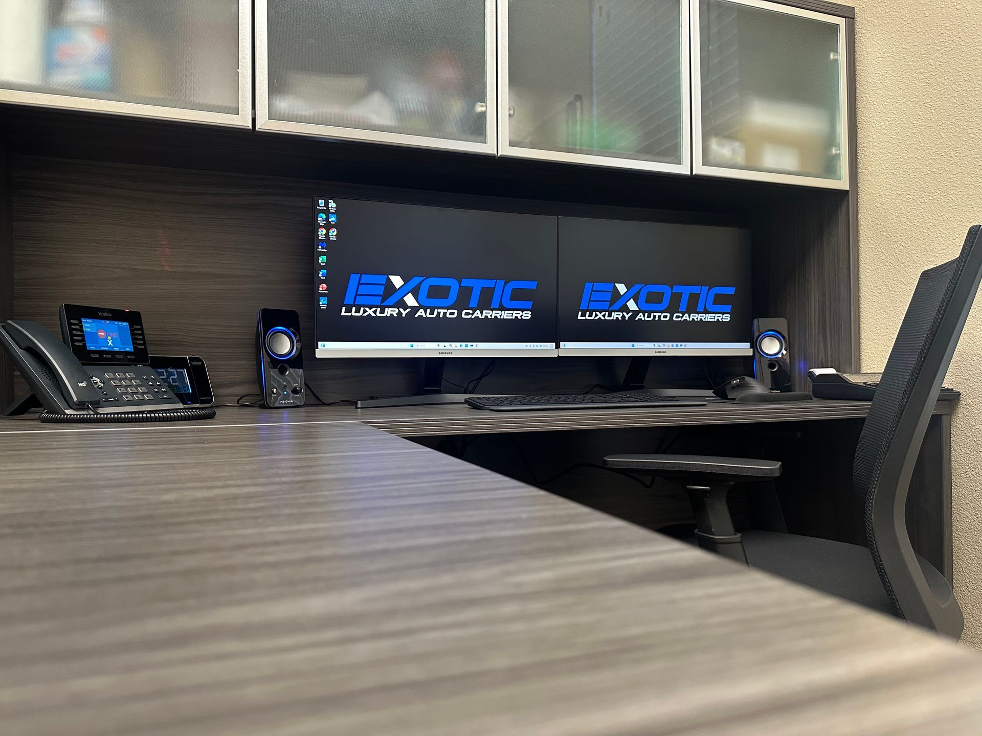 Office desk with dual monitors displaying 