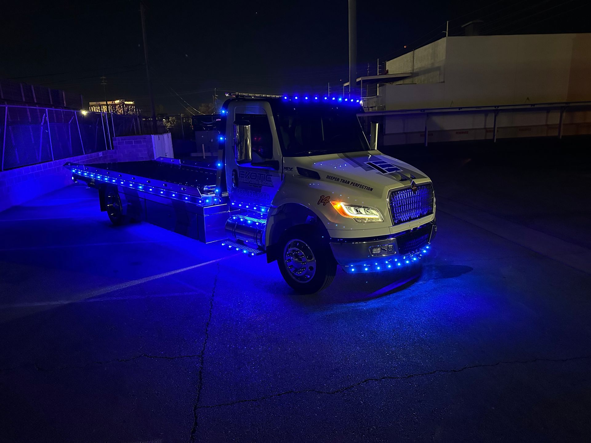 Tow truck with blue LED lights on at night.