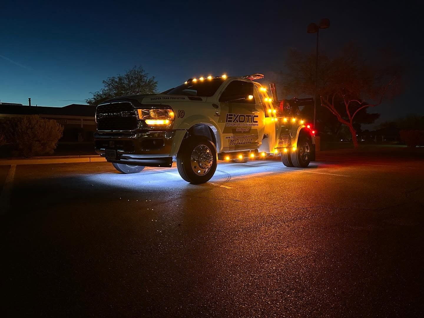 Tow truck with flashing amber lights at night.