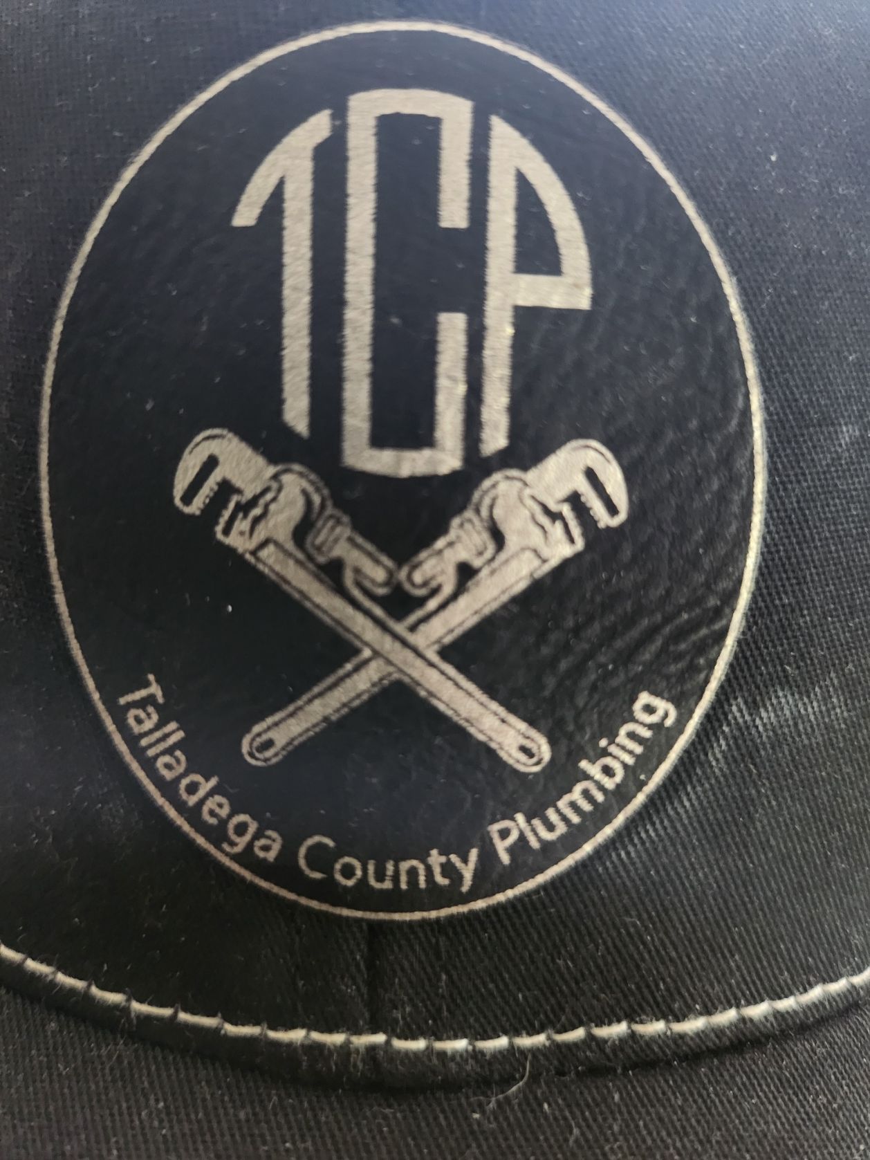 Logo on hat: Circular design with the initials 