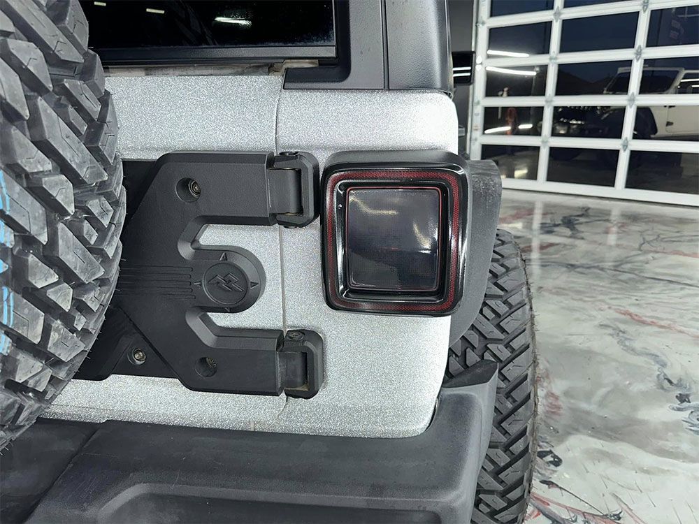 A jeep is parked in front of a garage door.