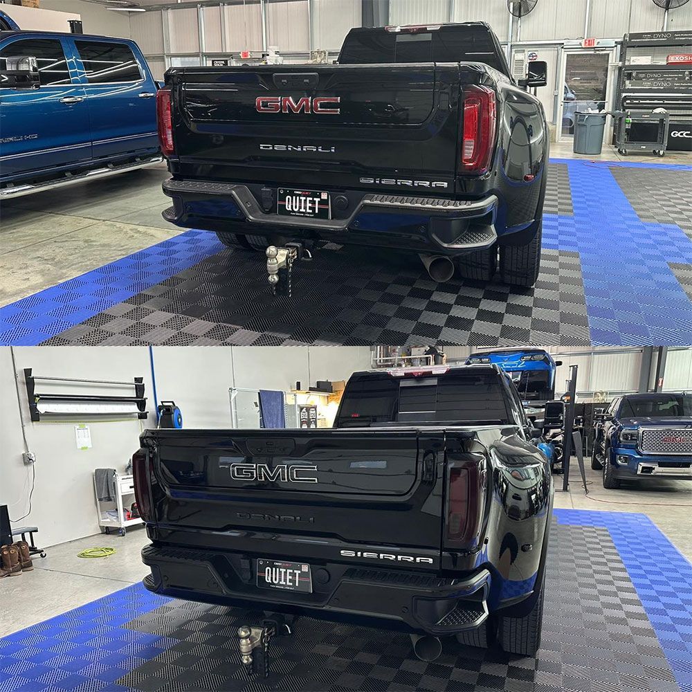 A black gmc truck is parked in a garage.