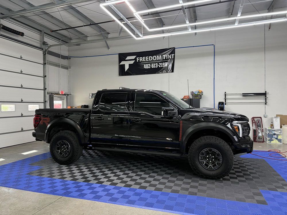 A black pickup truck is parked in a garage.