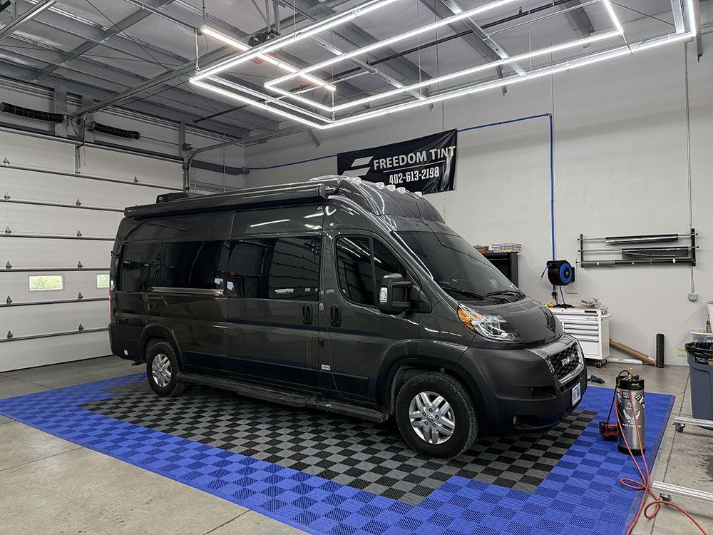 A van is parked in a garage with a checkered floor.