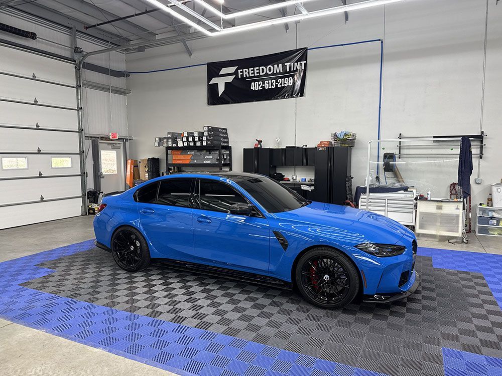 A blue bmw m3 is parked in a garage.