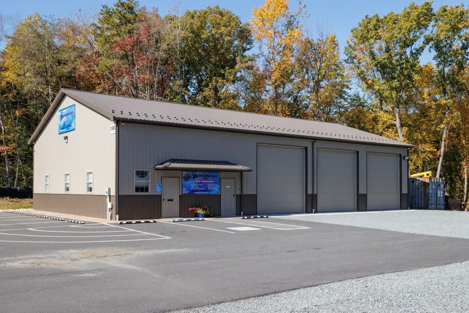 Tan industrial building with three garage doors and a small entrance.