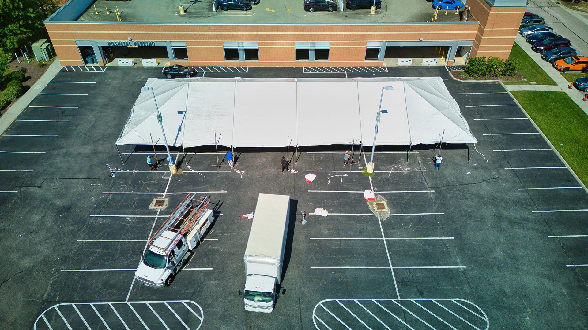 Aerial view of a parking lot with a large tent set up