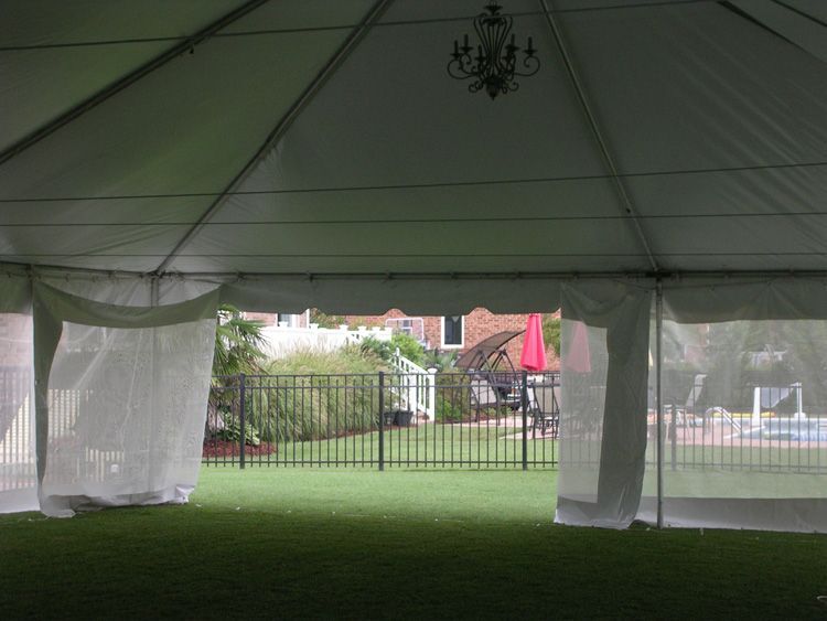 The inside of a white tent with a pool in the background