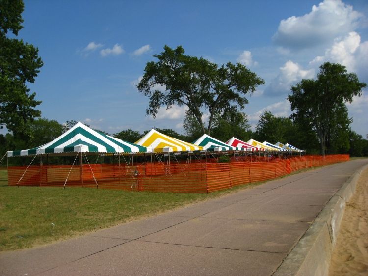 A row of tents are lined up on the side of a road