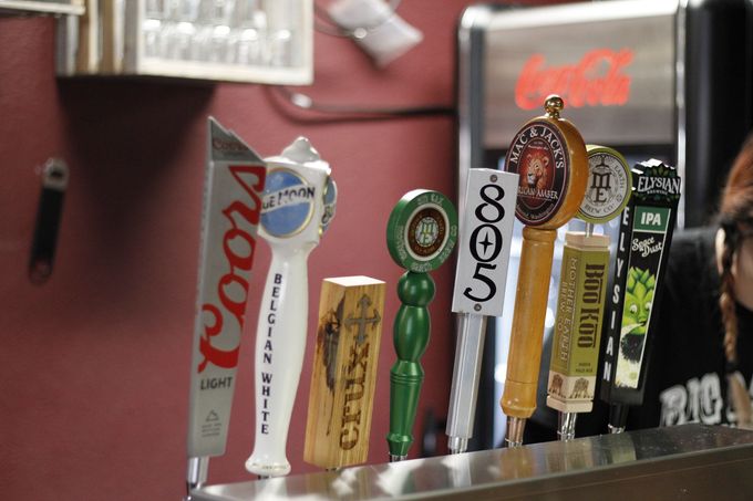 Several beer taps are lined up on a bar including coors light