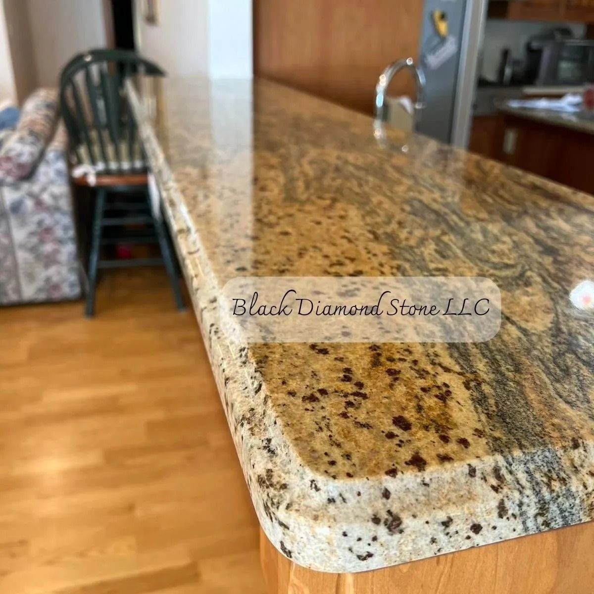 Granite countertop in a kitchen; light brown with dark brown speckles.