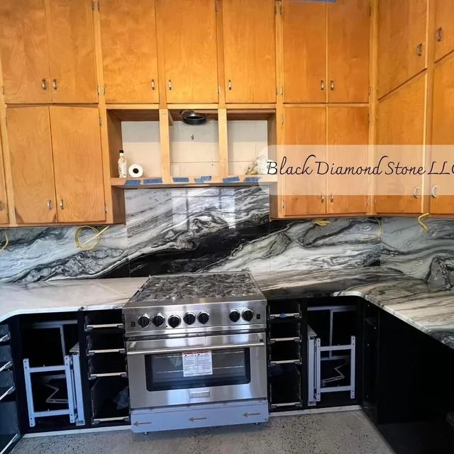 Kitchen under renovation with granite countertops and stainless steel range. Cabinets are wood.