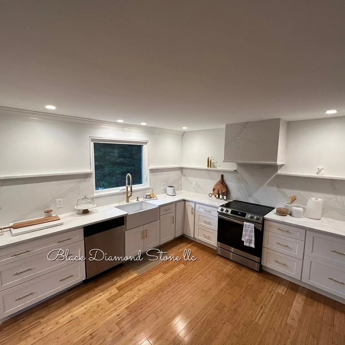 White kitchen with stainless steel appliances, marble backsplash, and hardwood floors.