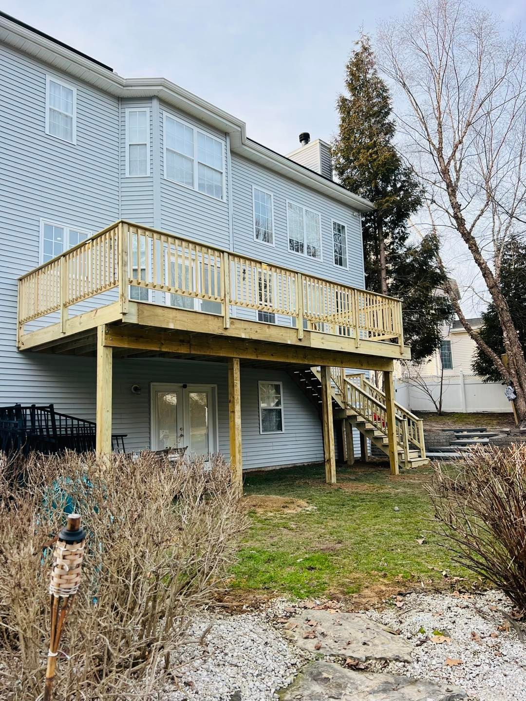 A large house with a large wooden deck in the backyard.
