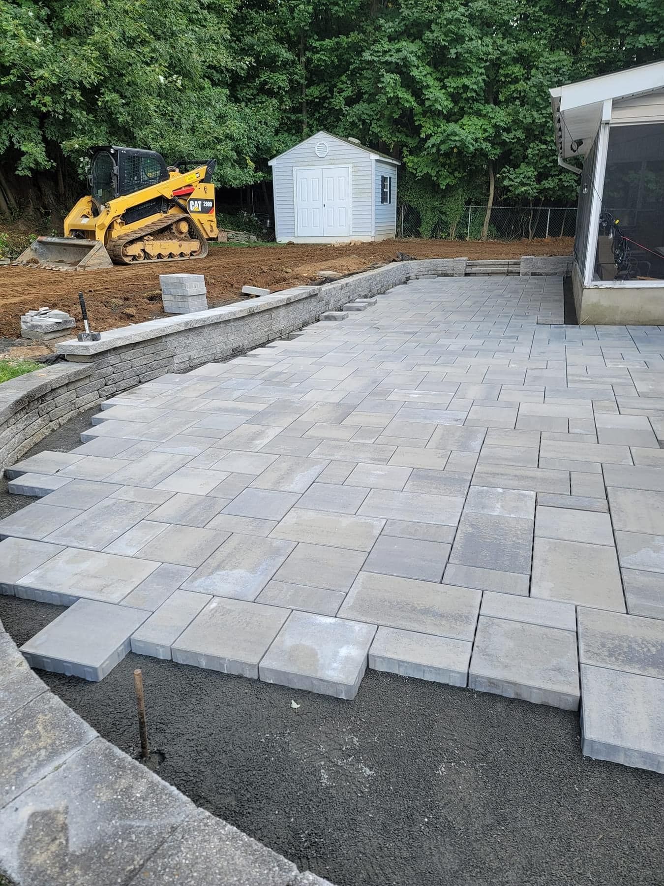 A patio is being built in the backyard of a house.