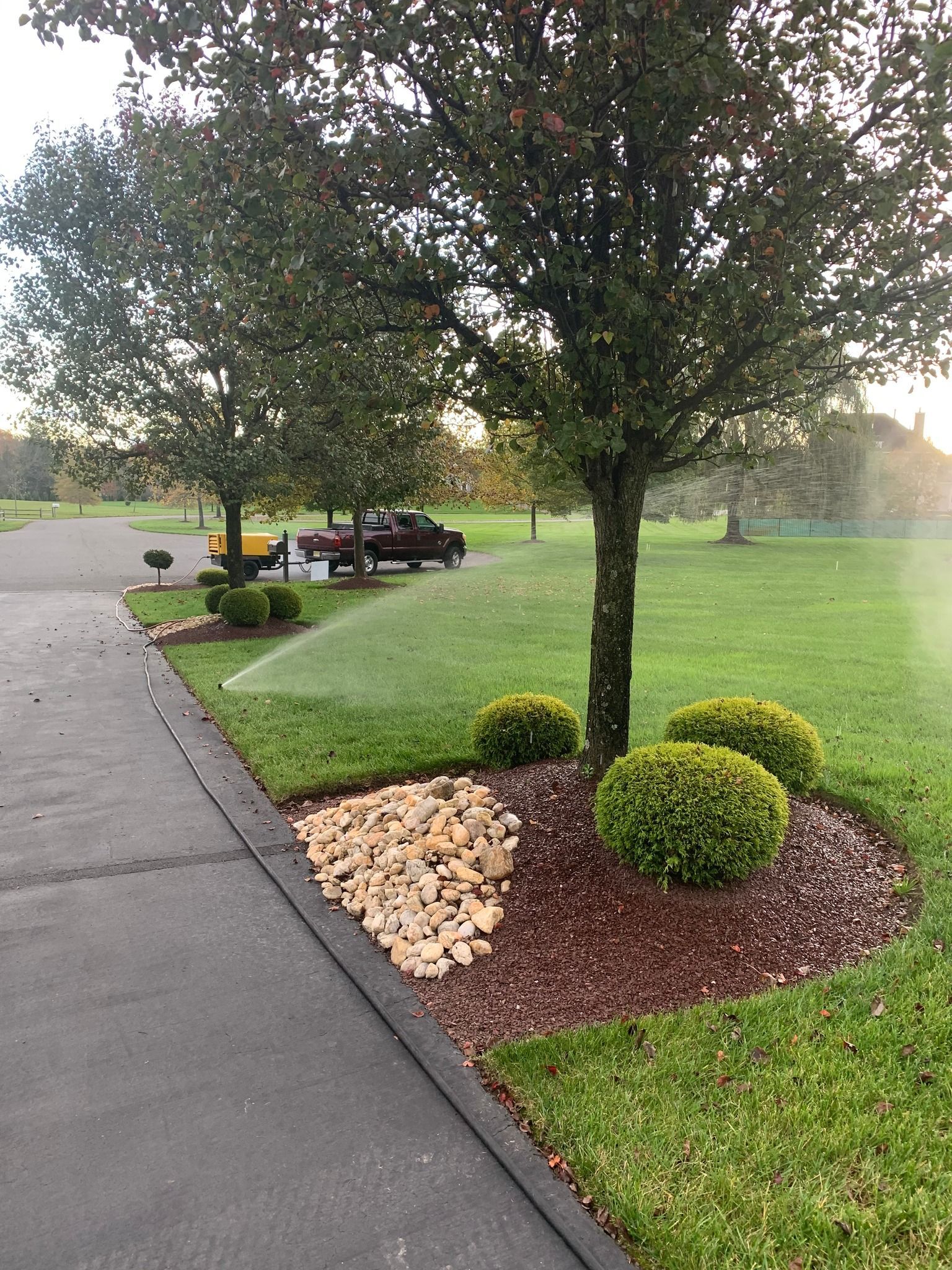 A sprinkler is spraying water on a lush green lawn.