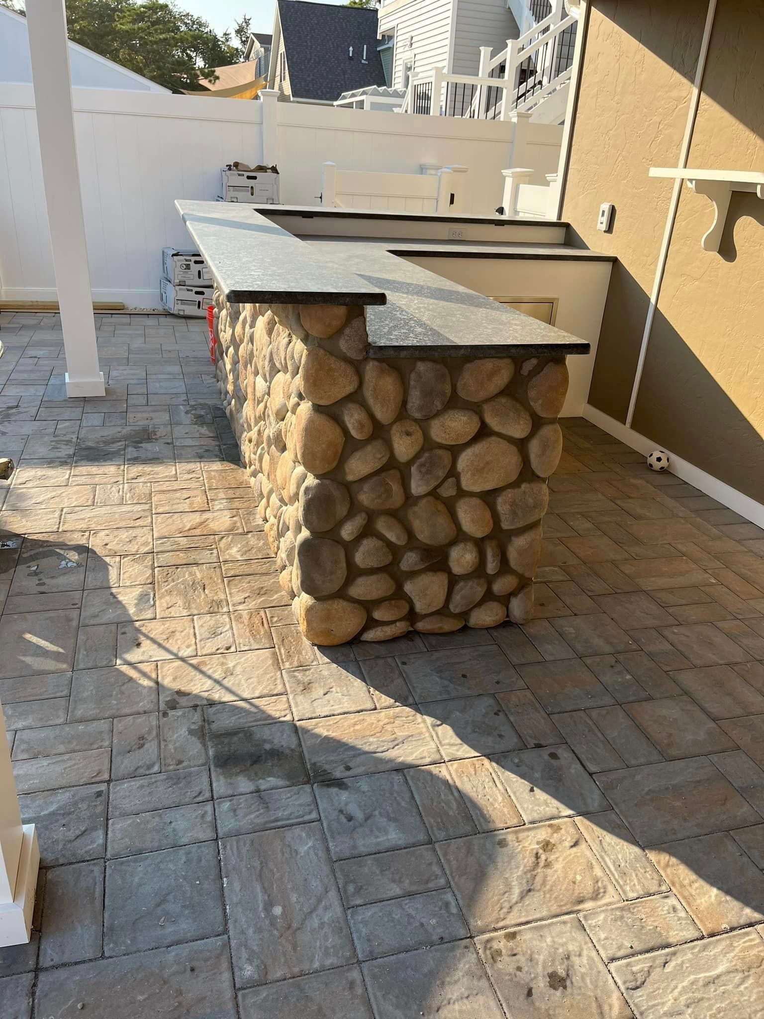 A stone bar is sitting on top of a brick patio.