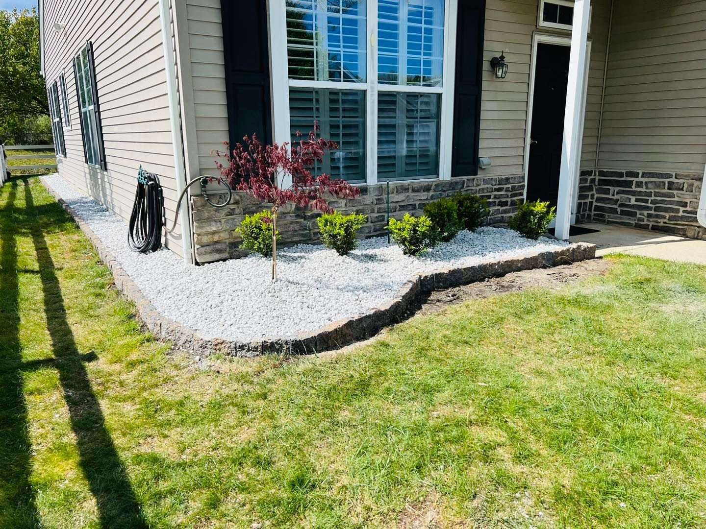 A house with a lush green lawn in front of it.