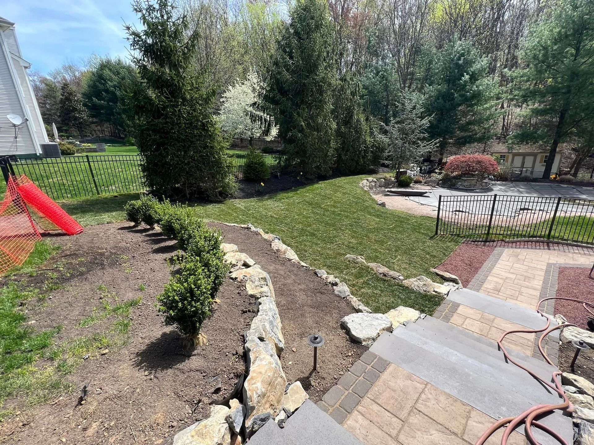 A lush green backyard with a patio and a slide.