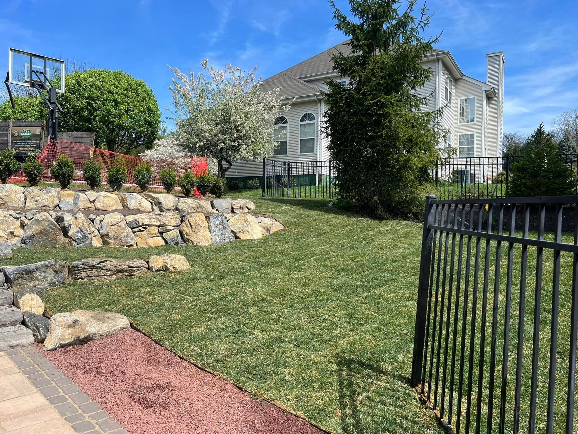 There is a basketball hoop in the backyard of a house.