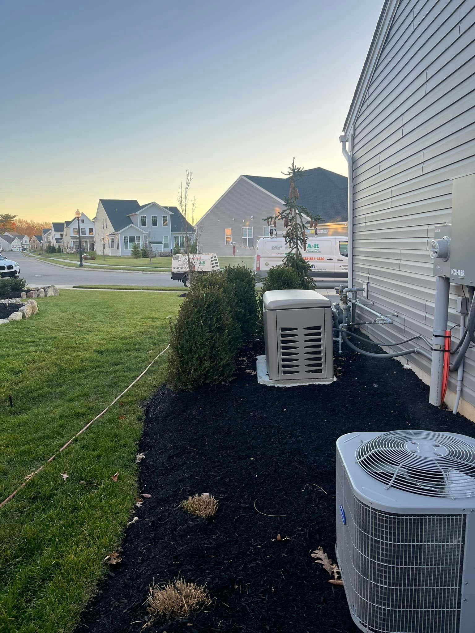 A couple of air conditioners are sitting on the side of a house.