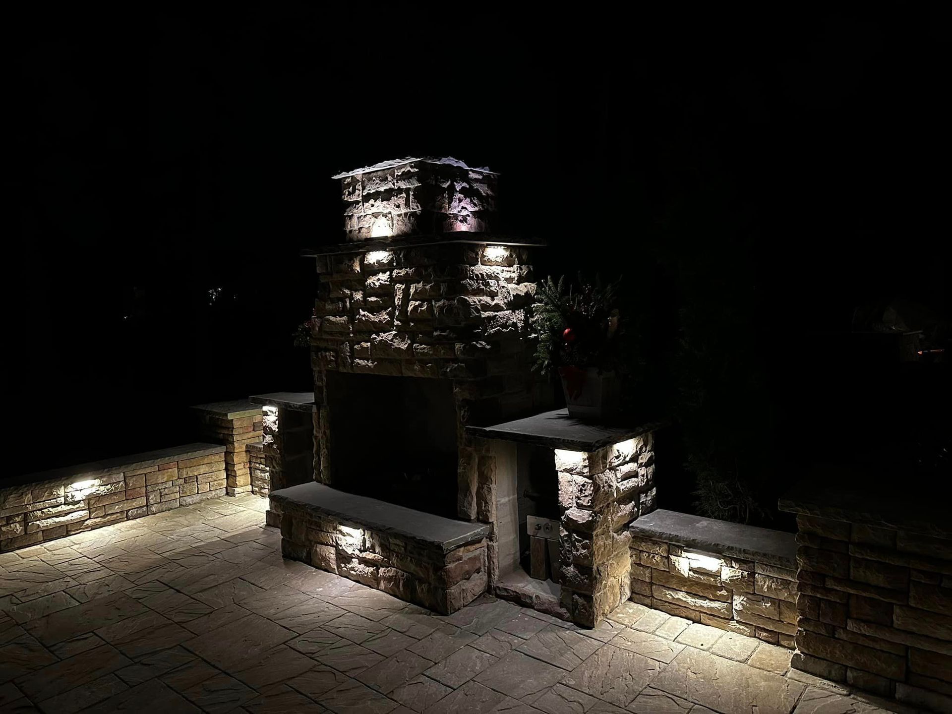 A stone fireplace is lit up at night