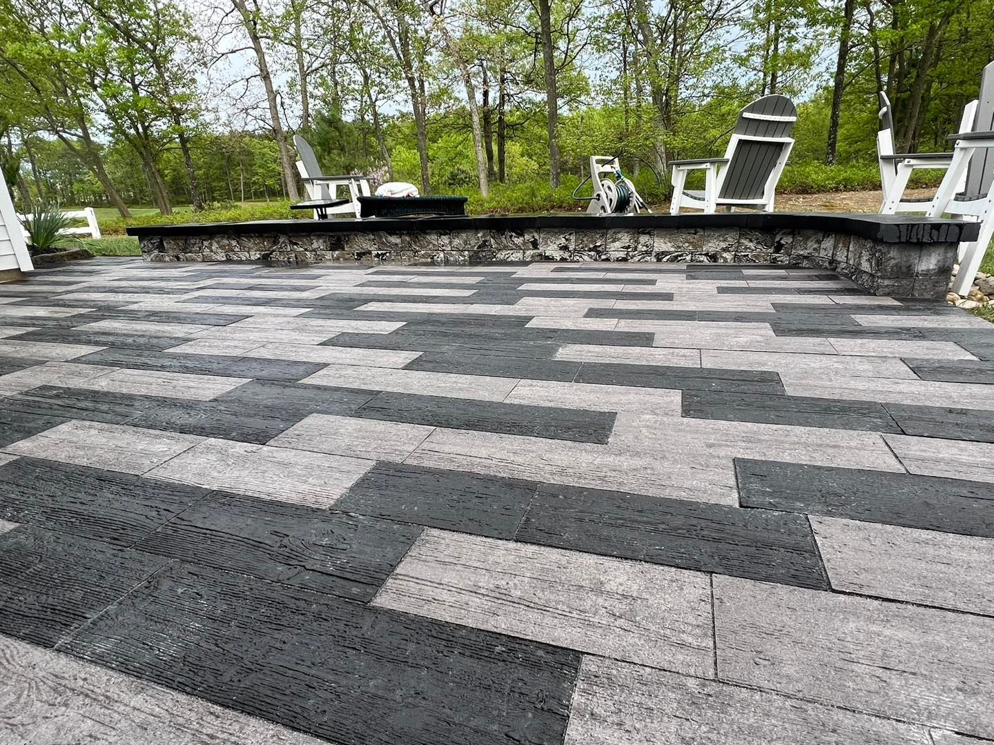 A black and white patio with chairs and trees in the background.
