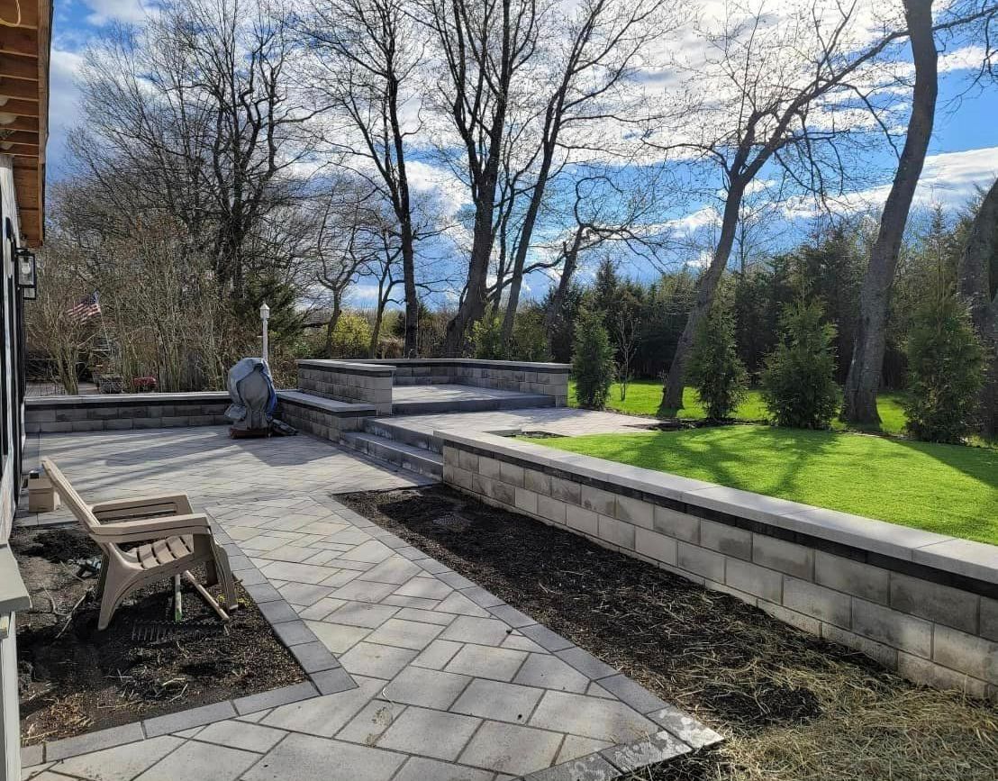 A patio with a chair and trees in the background on a sunny day.
