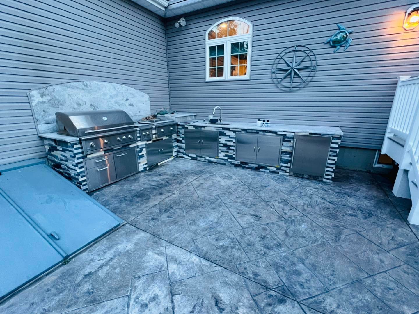 A patio with a grill and sink.