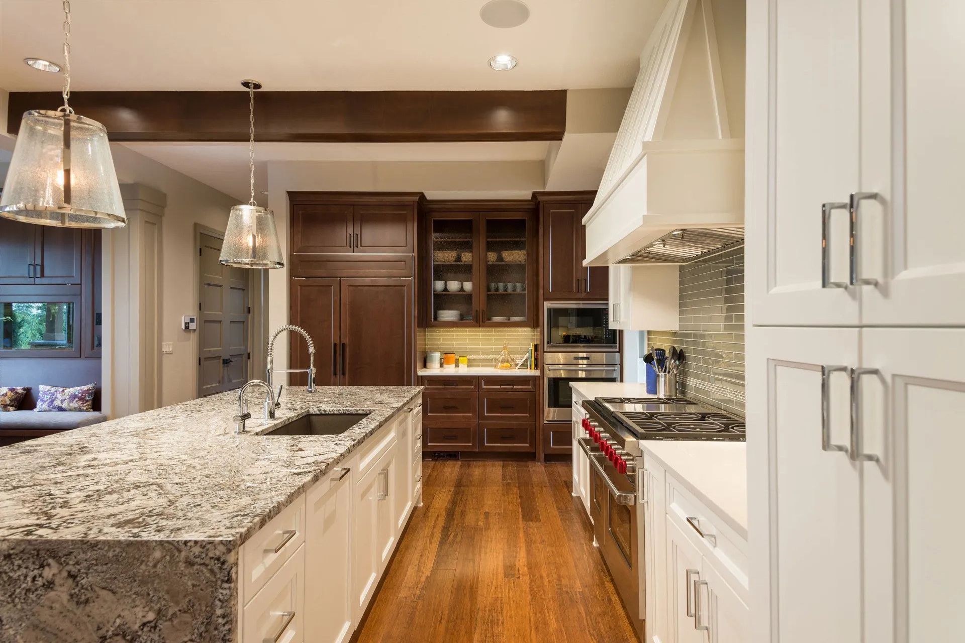 Spacious kitchen with a large island, dark wood cabinets, stainless steel appliances, and pendant lights.