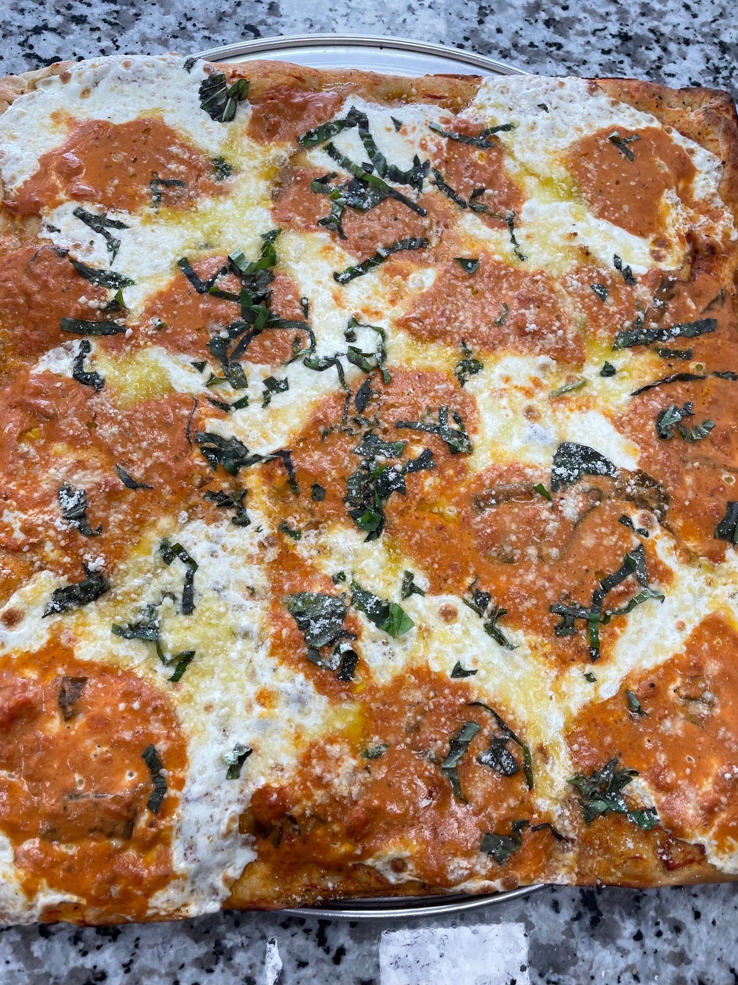 A pizza with tomato sauce and cheese is sitting on a table.