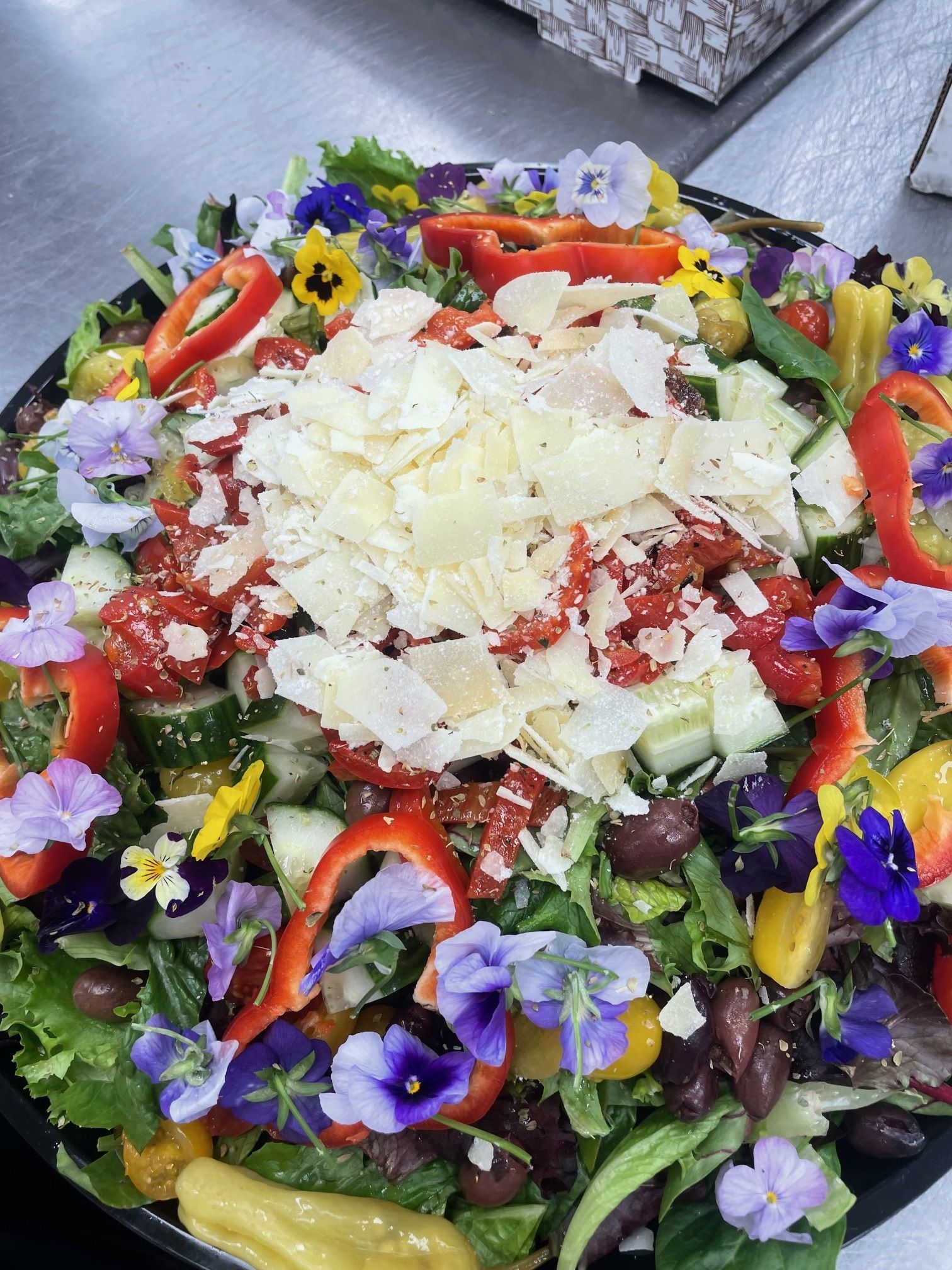 A salad with flowers and cheese on top of it