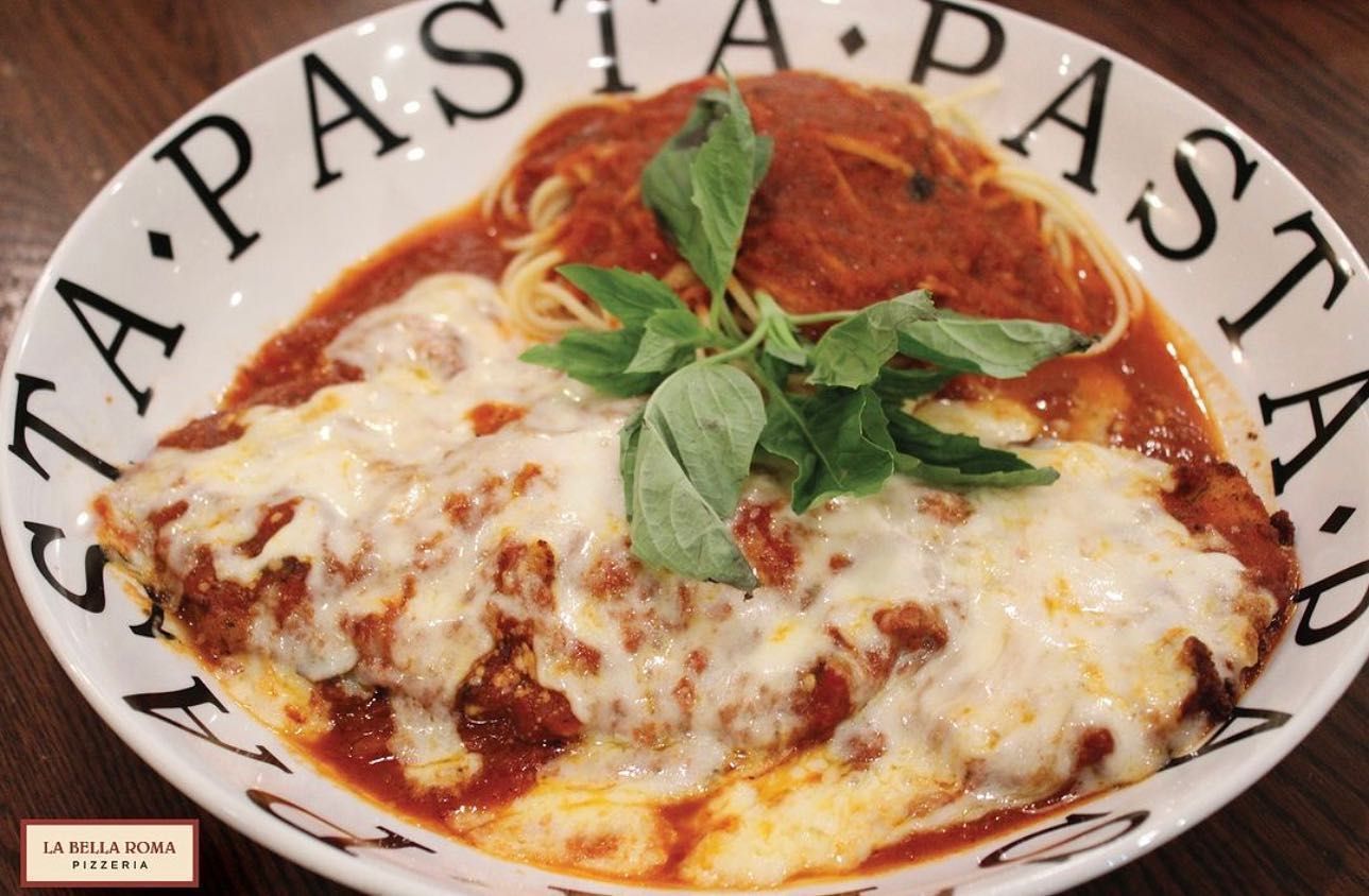 A plate of pasta with meat and cheese on a table
