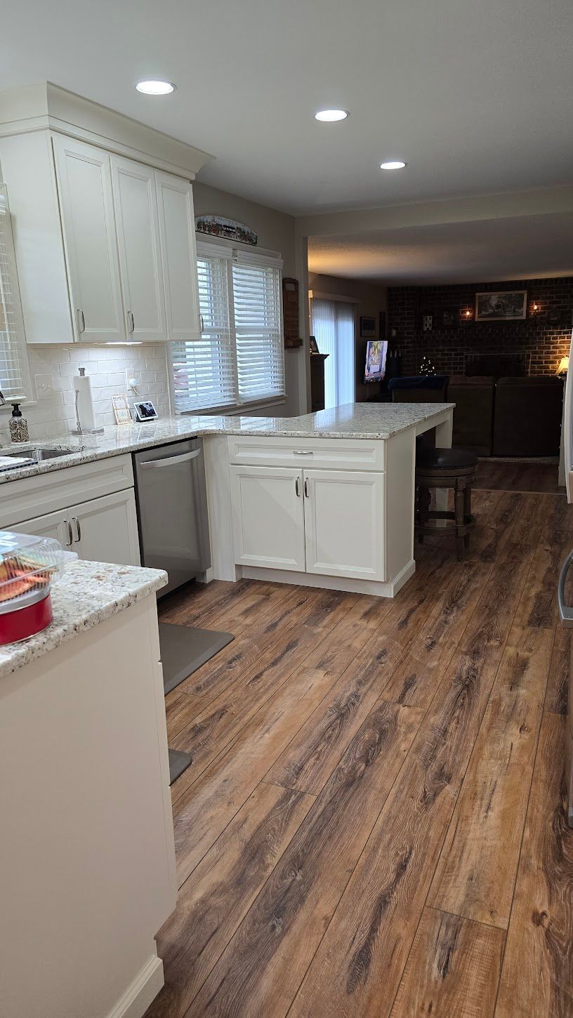 A kitchen with hardwood floors and white cabinets.