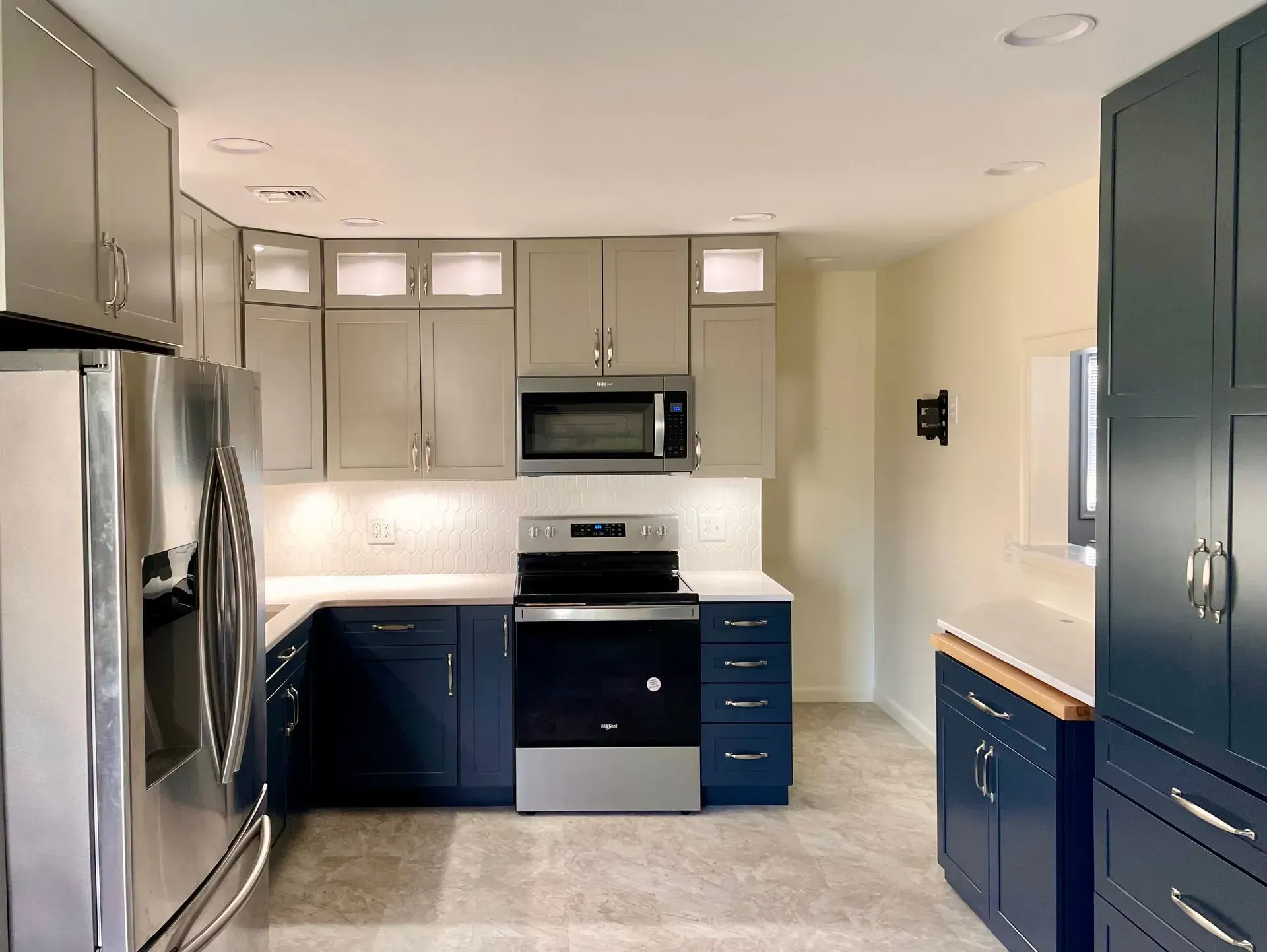 A kitchen with stainless steel appliances and blue cabinets