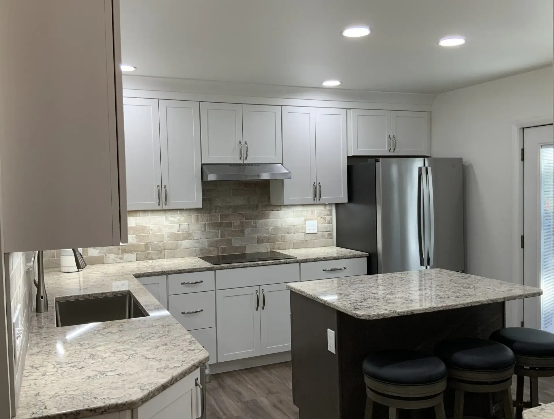 A kitchen with white cabinets and granite counter tops