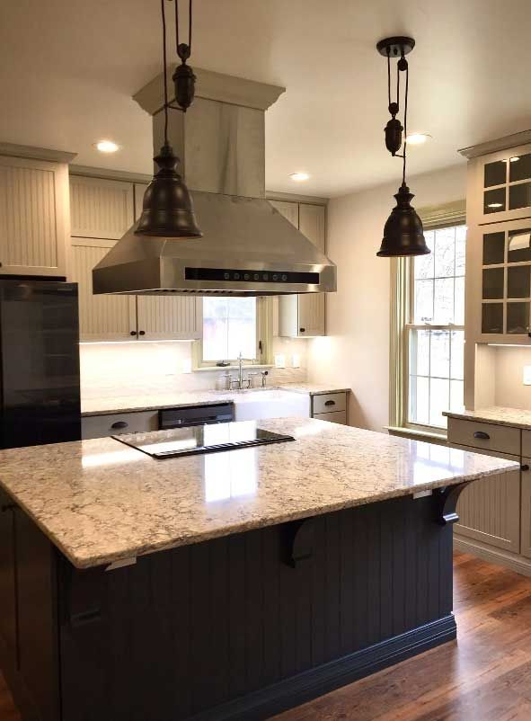 A kitchen with a large island and a stove top oven.