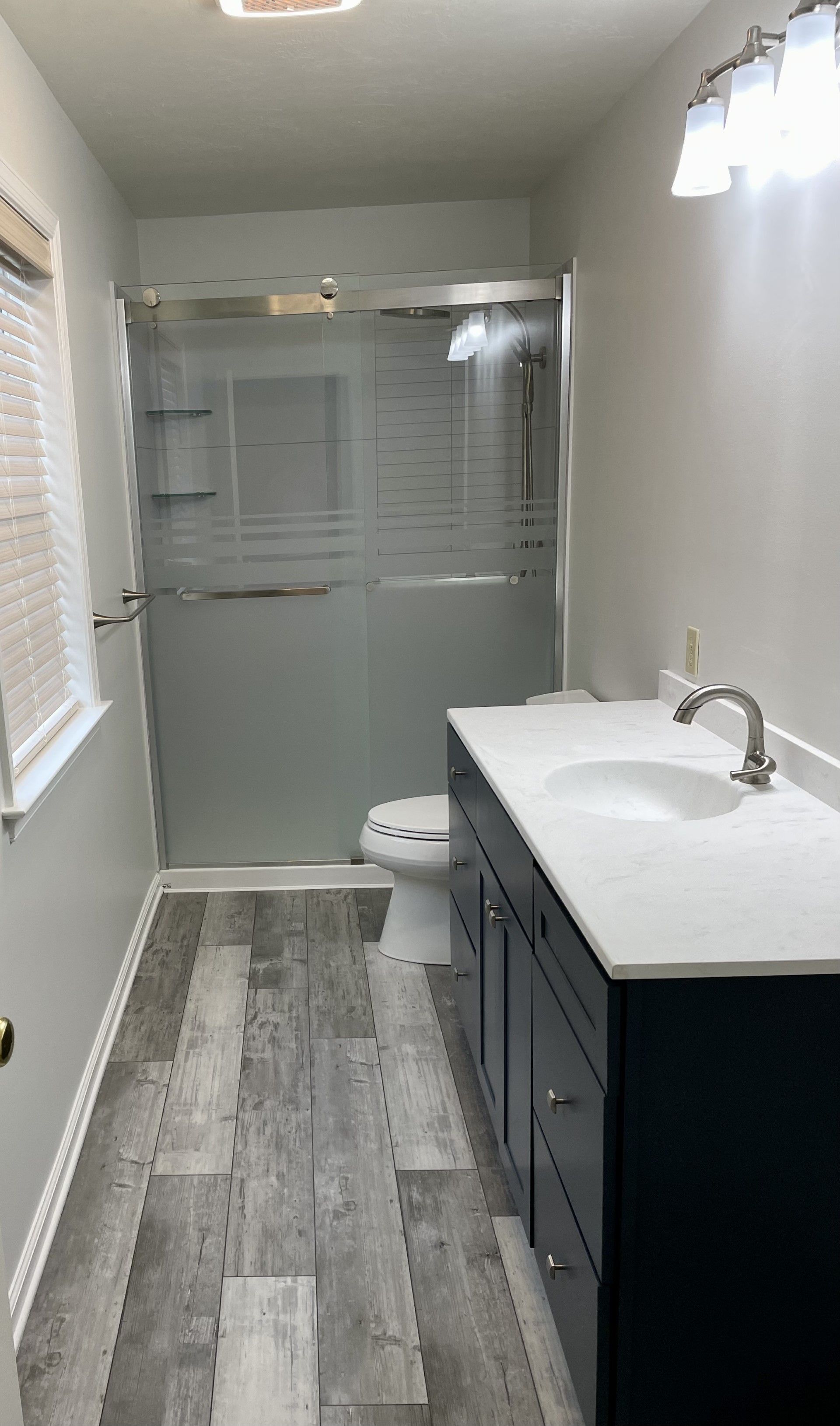 A bathroom with a sink , toilet and shower.