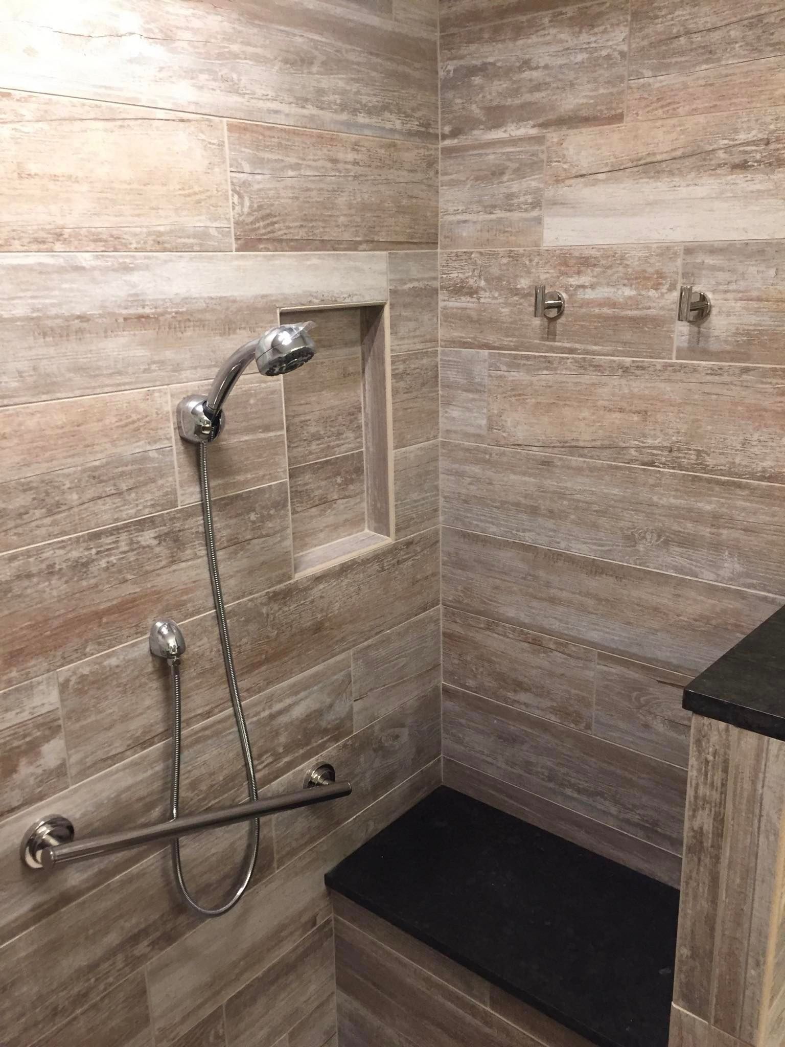 A bathroom with a shower and a bench.