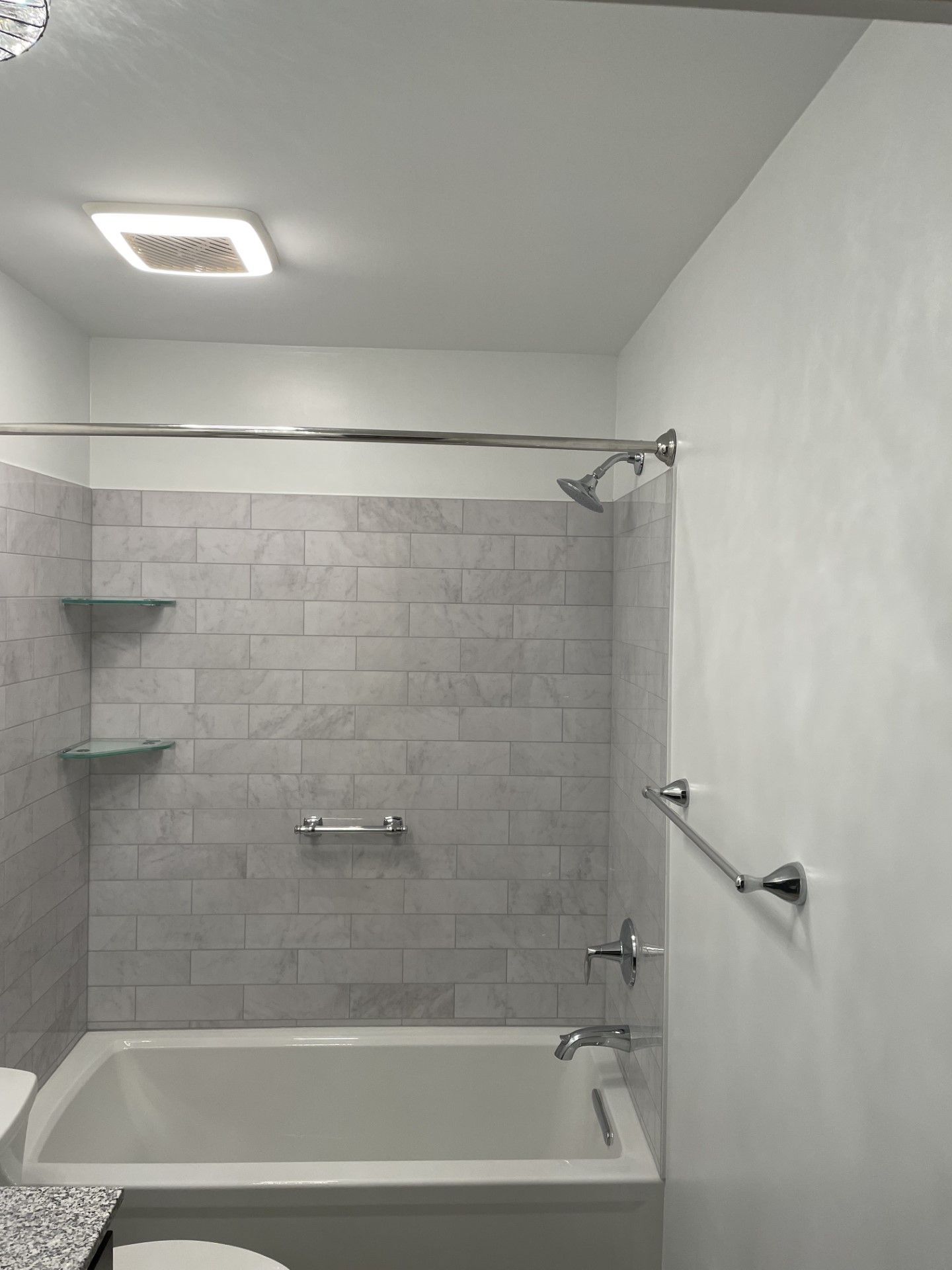 A bathroom with a bathtub , toilet and shower.