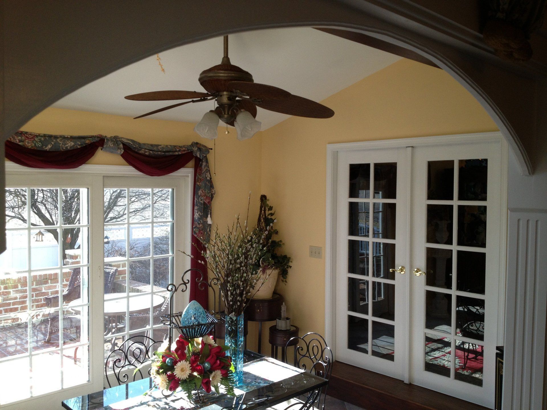 A living room with a ceiling fan and french doors