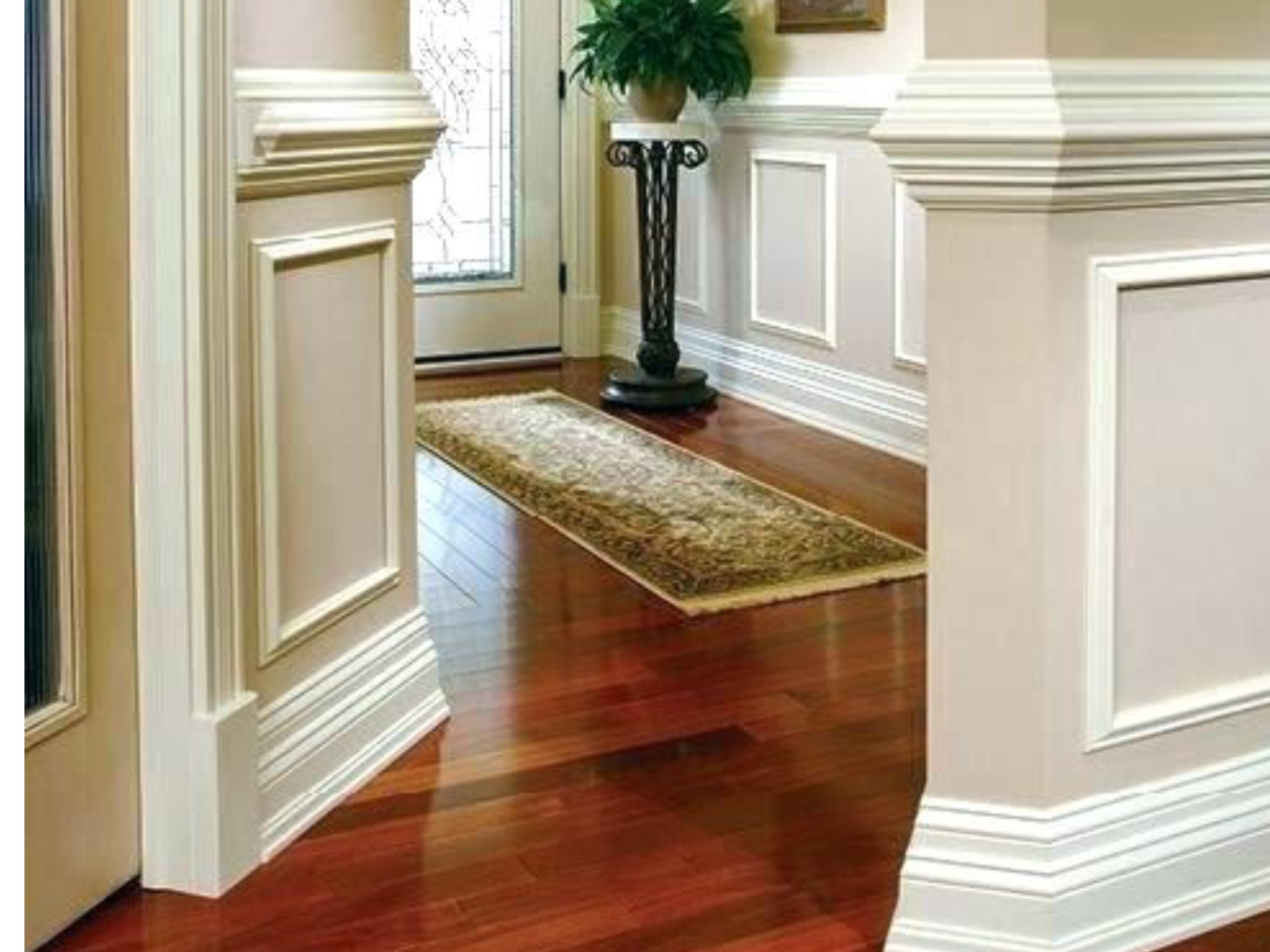 A hallway with hardwood floors and white trim