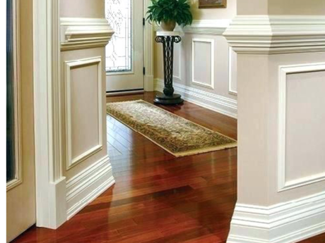 A corner of a room with a wooden ceiling and white trim.