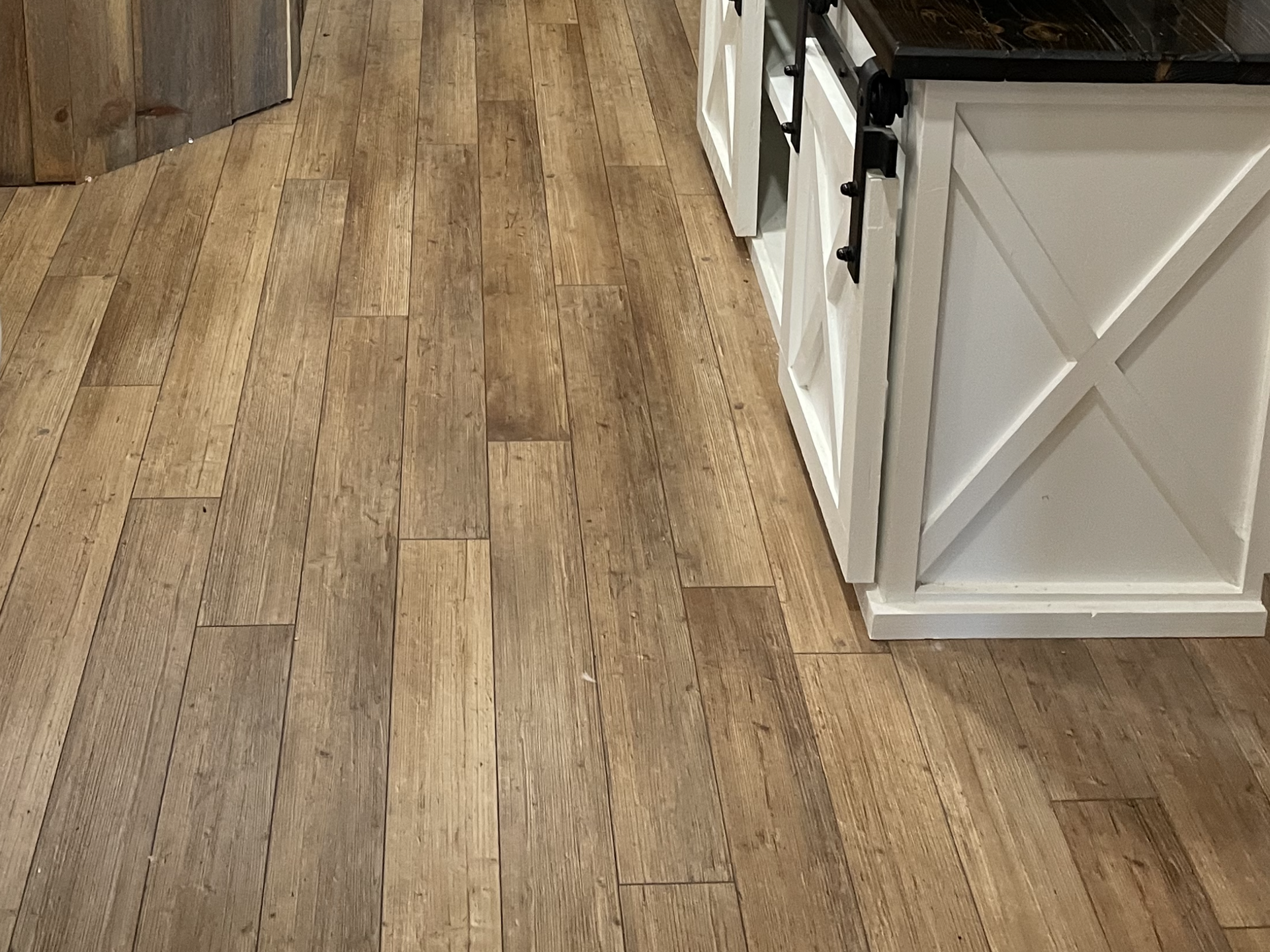 A kitchen with hardwood floors and white cabinets
