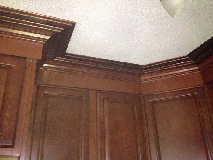 A kitchen with wooden cabinets and a white ceiling