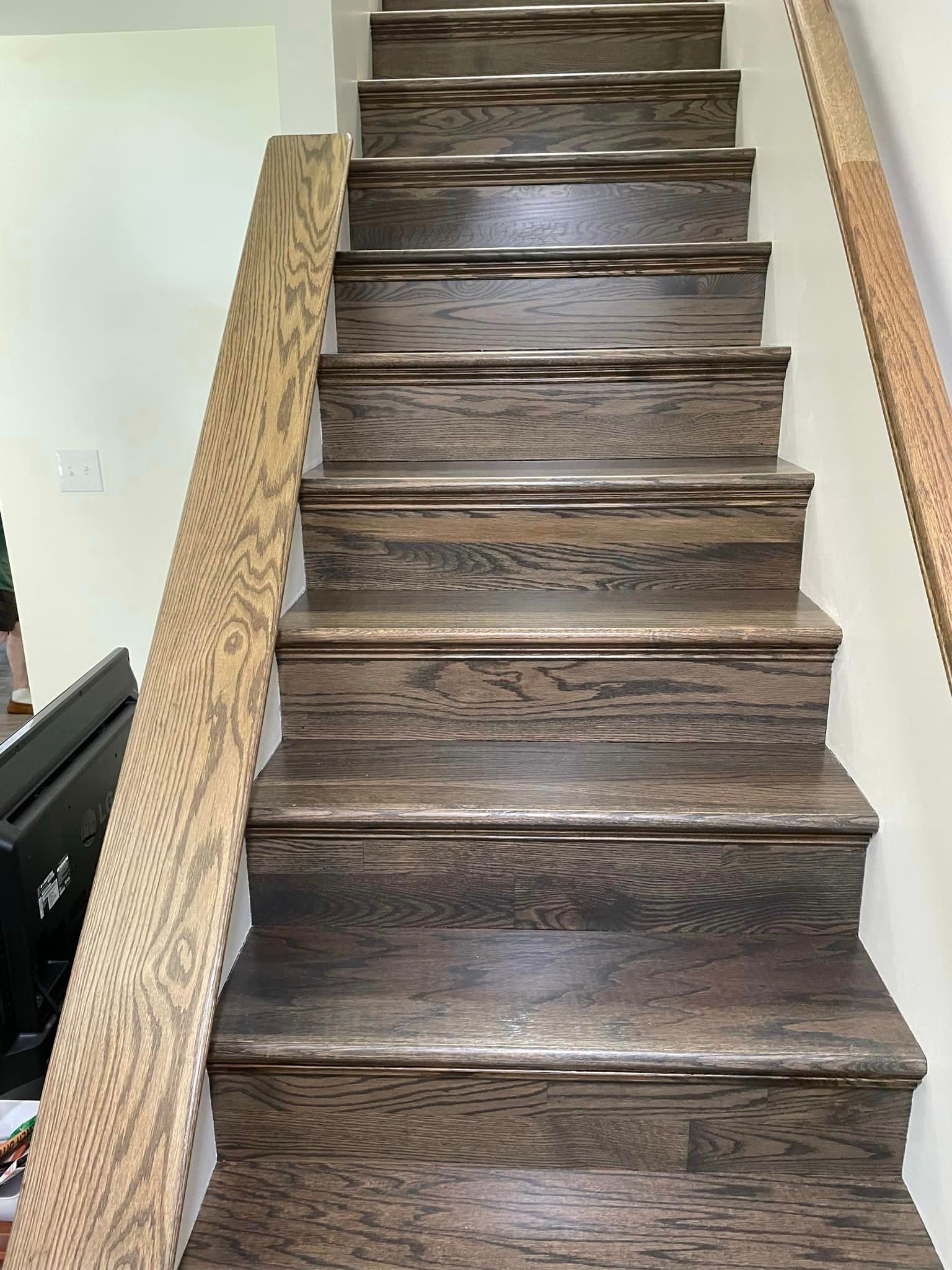 A wooden staircase with a wooden railing in a house.