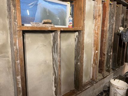 A man is plastering a wall with a trowel.