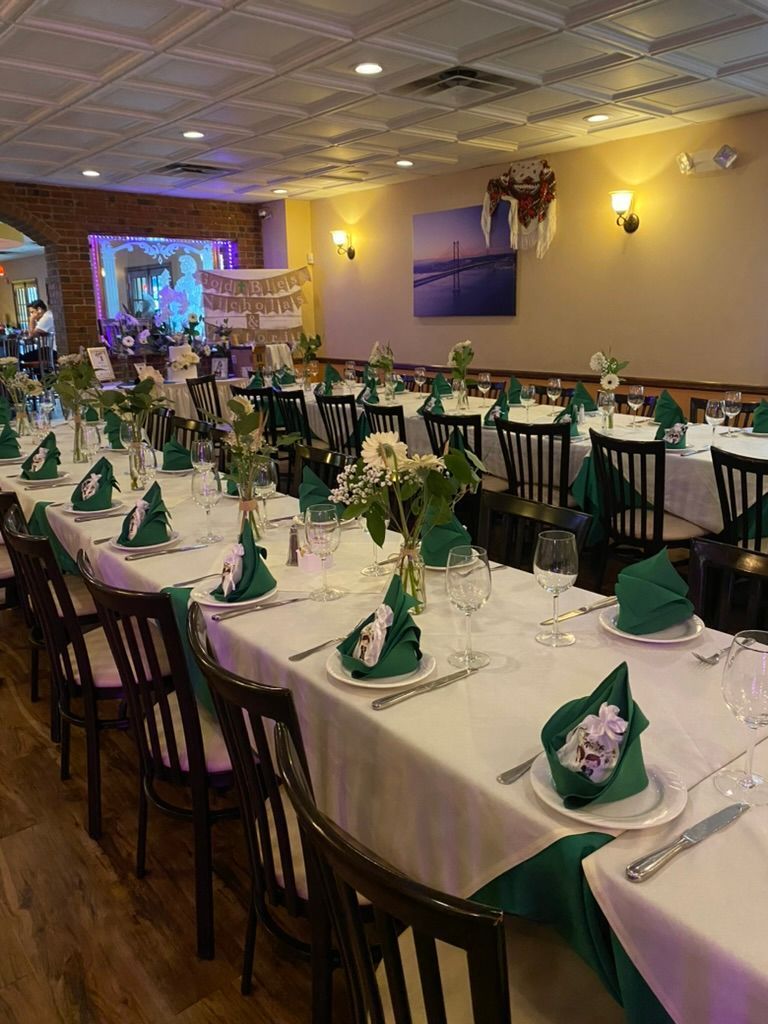 A large room with tables and chairs set up for a wedding reception.