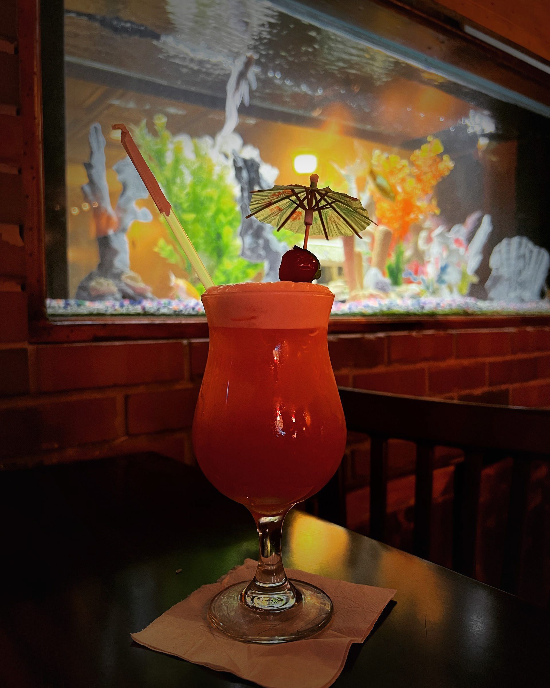 A drink in a glass with an umbrella on top of it