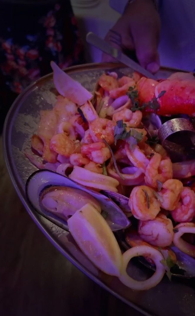 A plate of seafood with a spoon in it